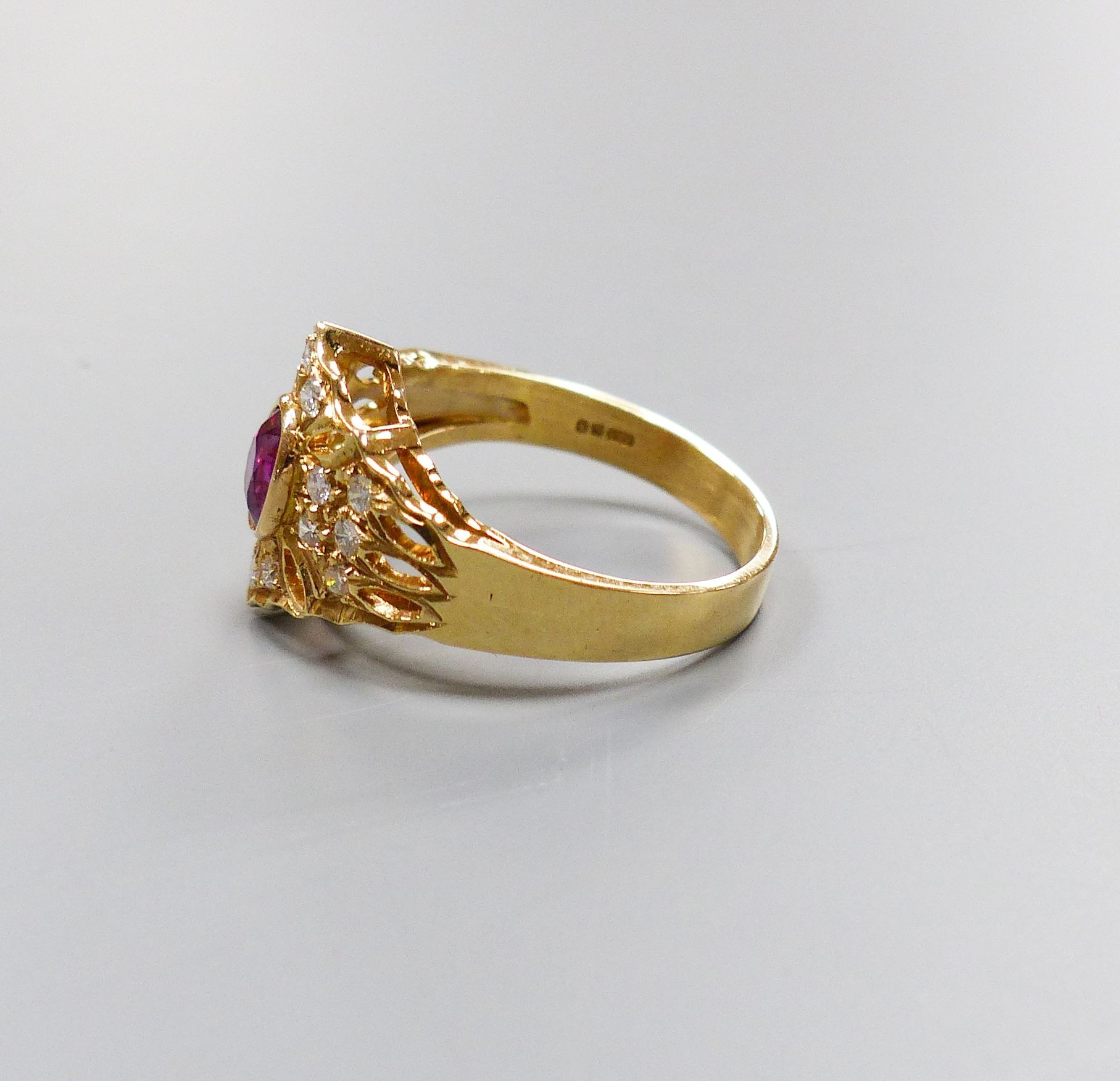 A modern 14ct gold, single stone ruby and diamond chip cluster set dress ring, size O, gross 4.1 grams.